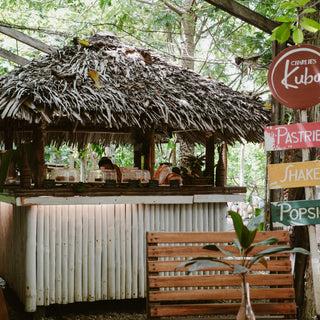 Cozy interior of Charlie's Kubo in Kalye Artisano with fresh shakes, coffee, and an assortment of pastries like croissants, chocolate chip banana bread, brownies, and ube crinkles.